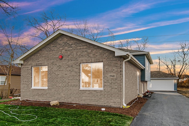 property exterior at dusk featuring a lawn and a garage