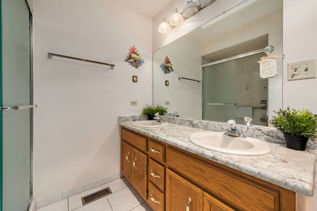 bathroom with tile patterned floors, vanity, and a shower with shower door