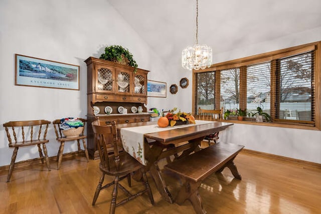 dining space featuring high vaulted ceiling, a chandelier, and light wood-type flooring