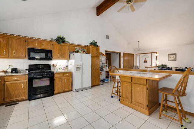 kitchen featuring kitchen peninsula, high vaulted ceiling, a breakfast bar area, and black appliances