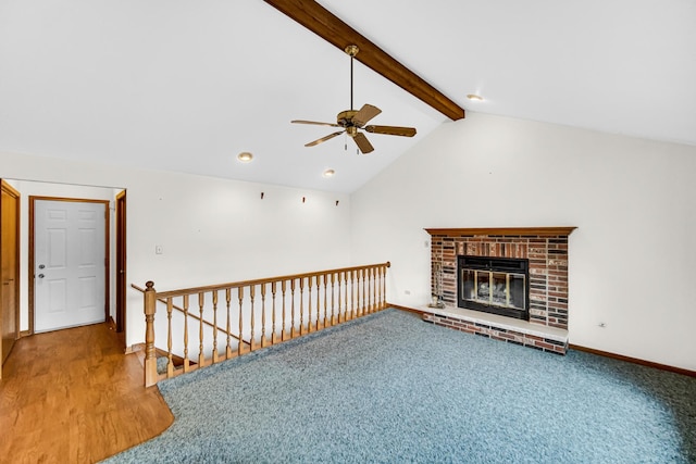 unfurnished living room featuring carpet, ceiling fan, lofted ceiling with beams, and a fireplace