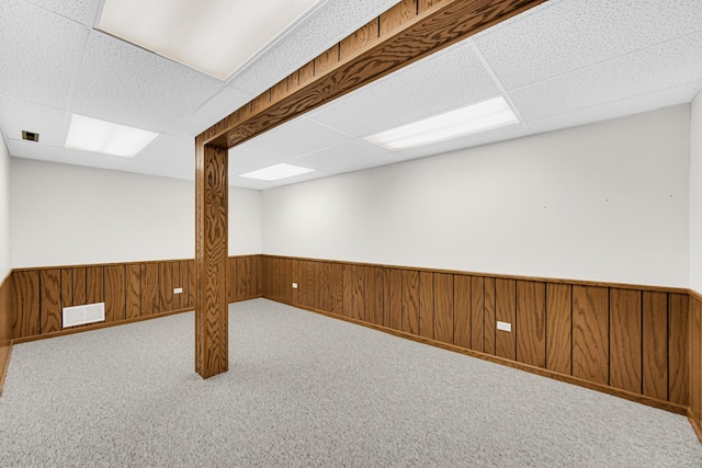 basement with a paneled ceiling and carpet floors