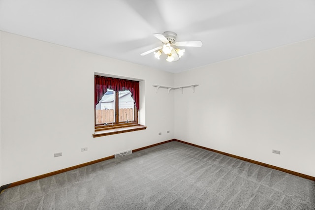 carpeted spare room featuring ceiling fan