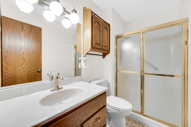 bathroom with vanity, toilet, and a shower with door