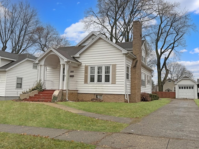 view of front of house featuring a front yard, a garage, and an outdoor structure