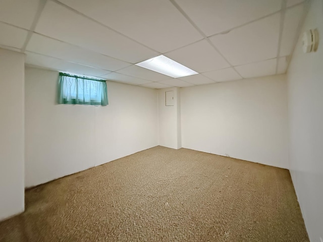 basement with carpet flooring and a paneled ceiling