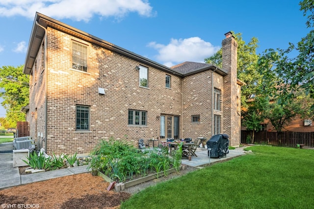 rear view of house with a yard and a patio