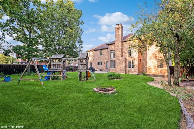 view of yard with a playground and a fire pit