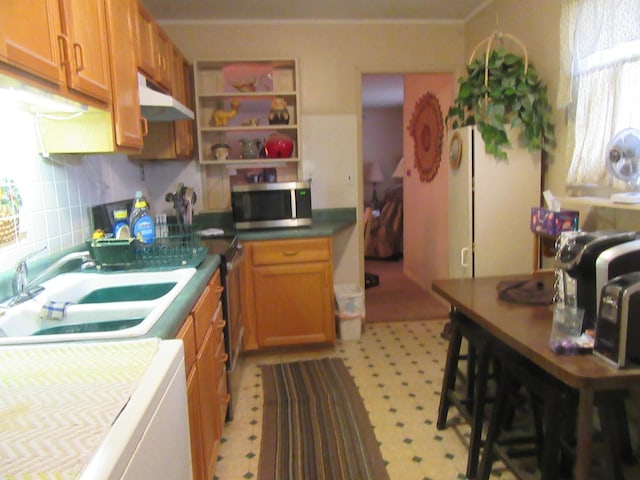 kitchen with a kitchen breakfast bar, tasteful backsplash, sink, and a healthy amount of sunlight