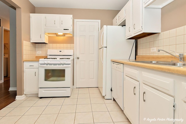 kitchen with white cabinets, backsplash, white appliances, and sink