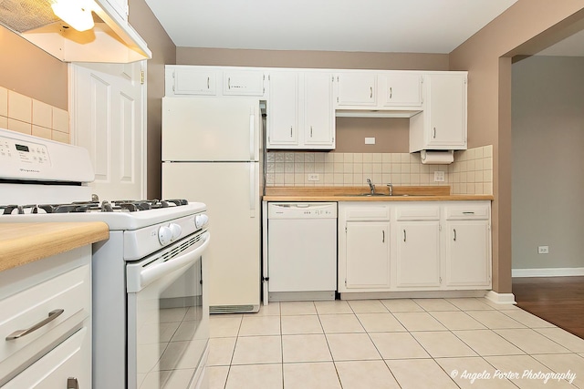 kitchen featuring tasteful backsplash, white appliances, sink, white cabinets, and light tile patterned flooring