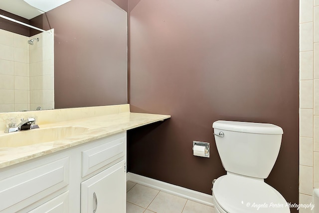 bathroom featuring tile patterned flooring, vanity, tiled shower, and toilet