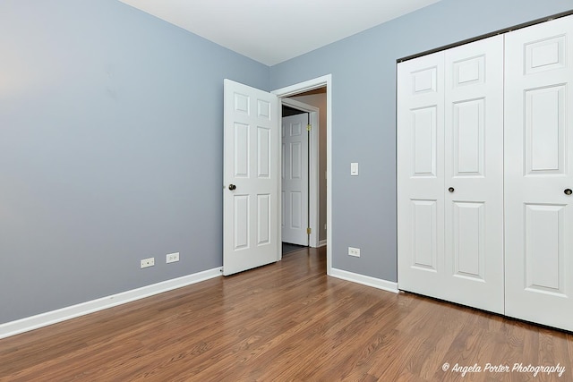 unfurnished bedroom with hardwood / wood-style flooring and a closet