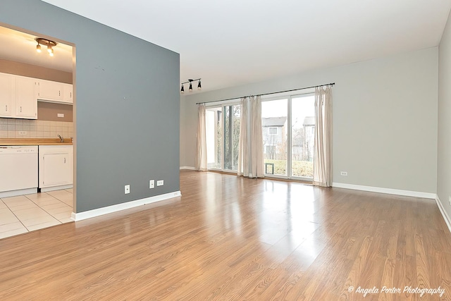 unfurnished living room with light wood-type flooring and sink