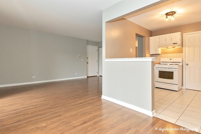 kitchen with white range oven, white cabinetry, tasteful backsplash, and light hardwood / wood-style flooring