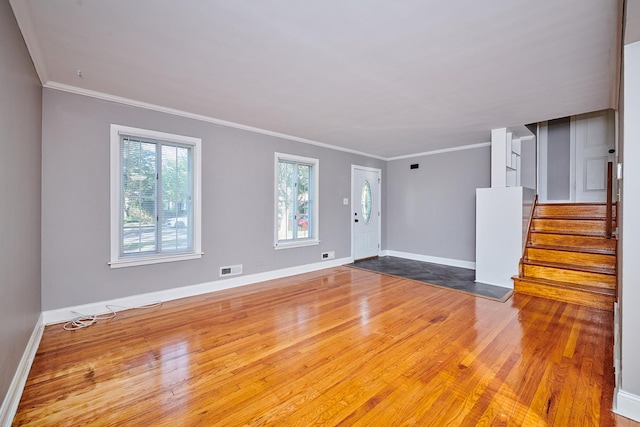 unfurnished living room featuring hardwood / wood-style floors and crown molding