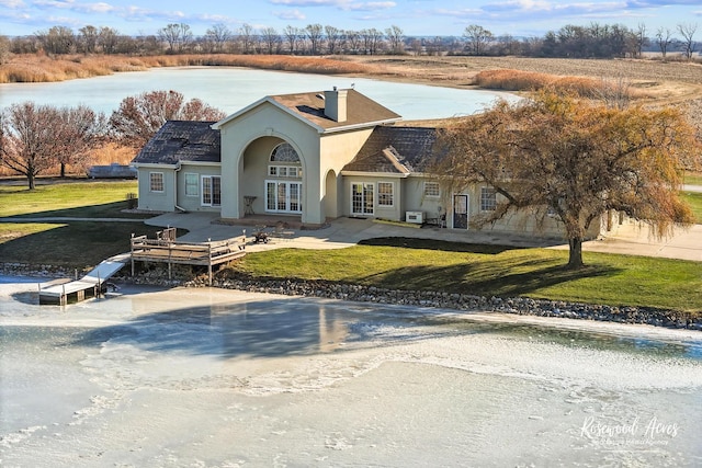 view of front of home with french doors, a deck with water view, and a front yard