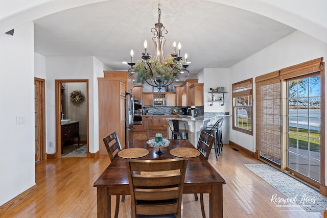 dining space featuring a chandelier and light wood-type flooring