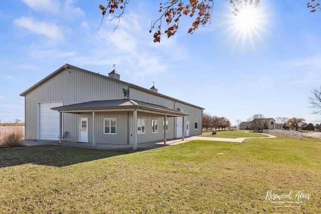 rear view of house with a garage and a yard