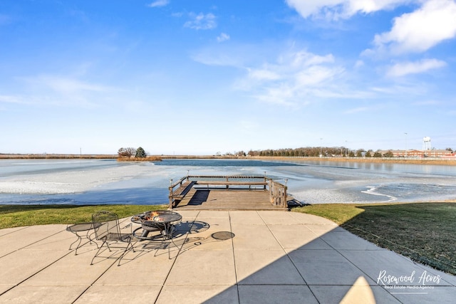 view of patio with a water view and an outdoor fire pit