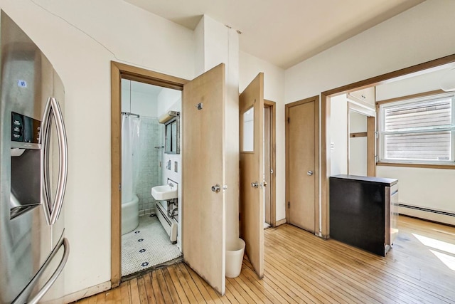 hall featuring light wood-type flooring and a baseboard radiator