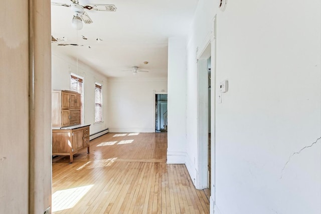 hall with a baseboard radiator and light wood-type flooring