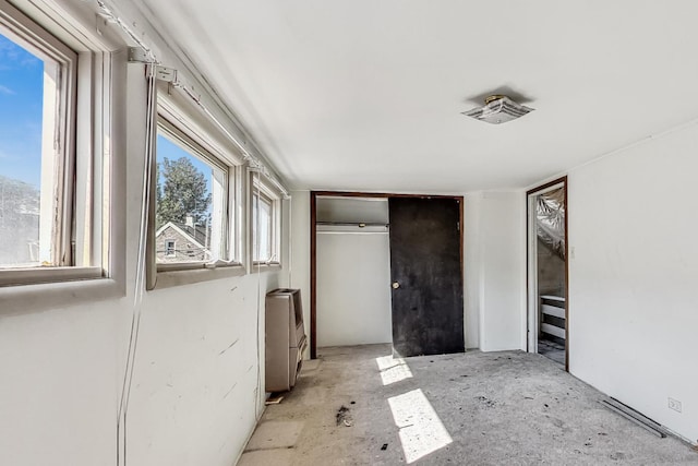 unfurnished bedroom with a closet and multiple windows