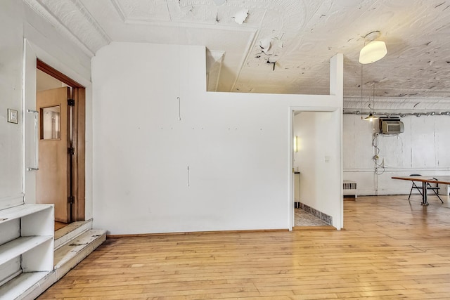 unfurnished room featuring hardwood / wood-style flooring and radiator