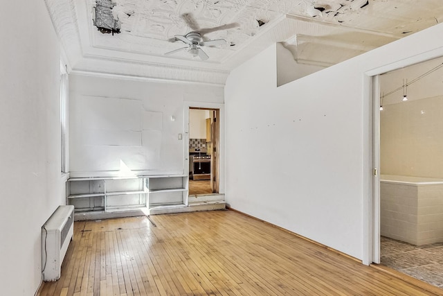 unfurnished living room with ceiling fan and wood-type flooring