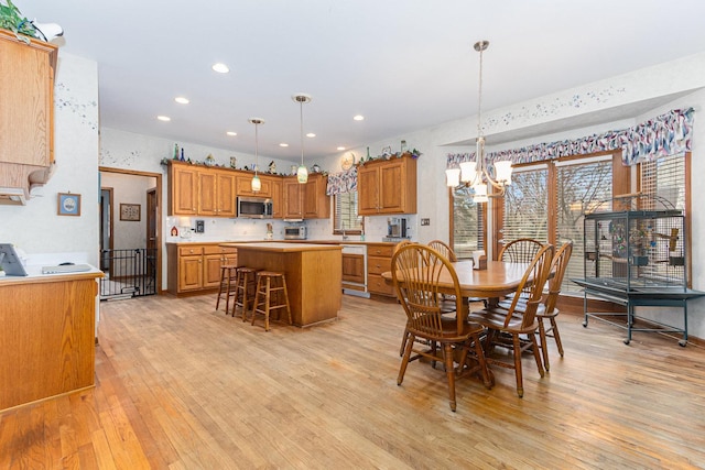 dining space featuring light hardwood / wood-style floors and an inviting chandelier