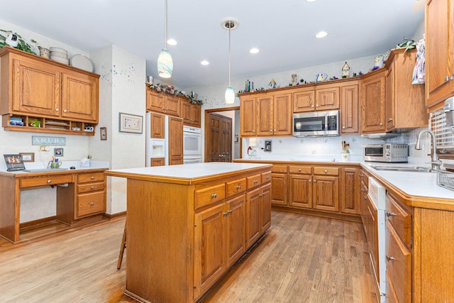 kitchen featuring pendant lighting, light hardwood / wood-style floors, a kitchen island, and sink