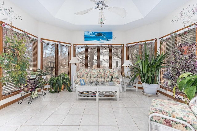 unfurnished sunroom featuring a raised ceiling and ceiling fan