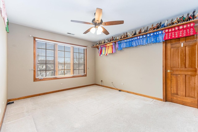 spare room with light colored carpet and ceiling fan