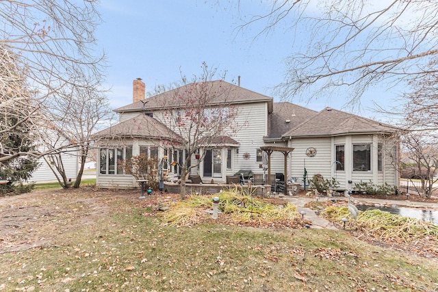 rear view of property featuring a yard and a sunroom