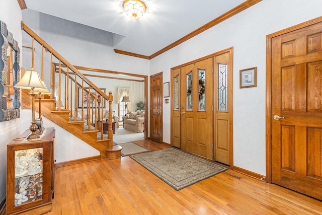 entryway featuring crown molding and light hardwood / wood-style flooring