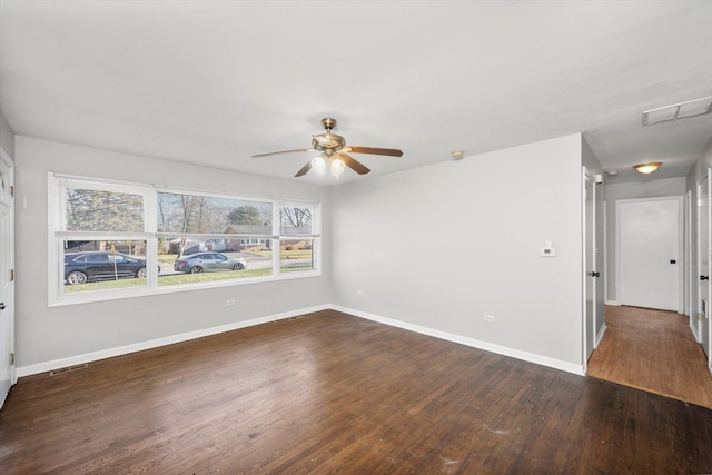 empty room with dark hardwood / wood-style floors and ceiling fan