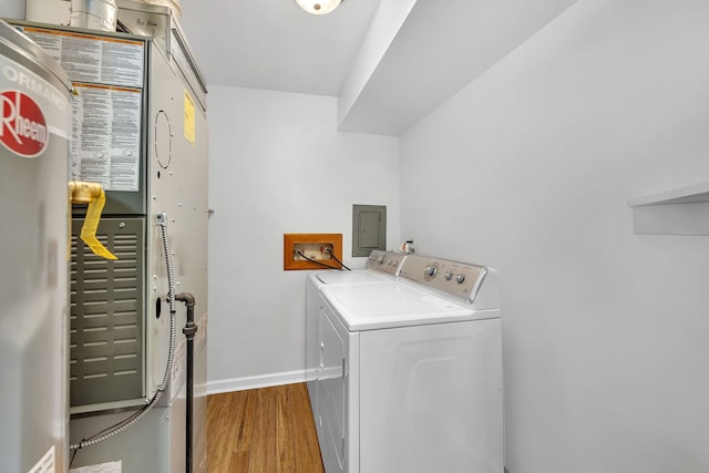 laundry room with wood-type flooring, independent washer and dryer, and electric panel