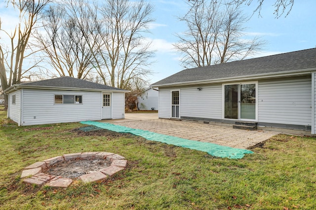 rear view of house featuring a patio area, a yard, and an outdoor fire pit