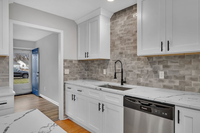 kitchen featuring light stone counters, sink, light hardwood / wood-style flooring, dishwasher, and white cabinetry