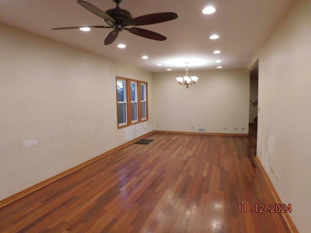 unfurnished room with hardwood / wood-style floors and ceiling fan with notable chandelier