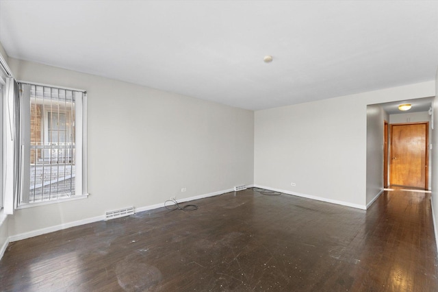 unfurnished room with dark wood-type flooring