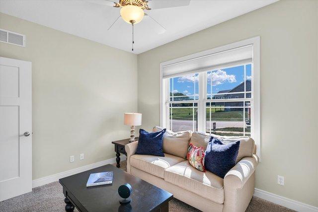 living room with ceiling fan and carpet