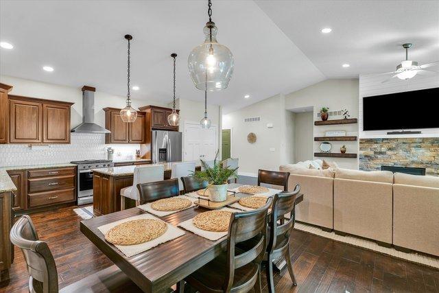 dining area with ceiling fan, dark hardwood / wood-style flooring, and vaulted ceiling