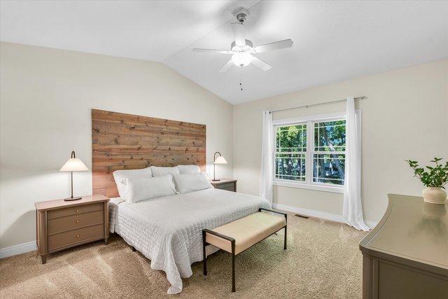 carpeted bedroom featuring vaulted ceiling and ceiling fan