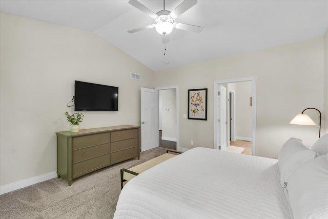 carpeted bedroom featuring vaulted ceiling and ceiling fan