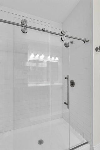 bathroom featuring a shower with shower door