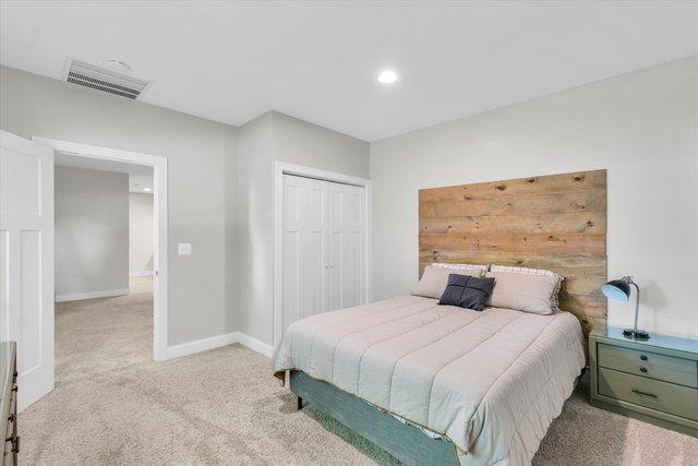 bedroom with light carpet and a closet