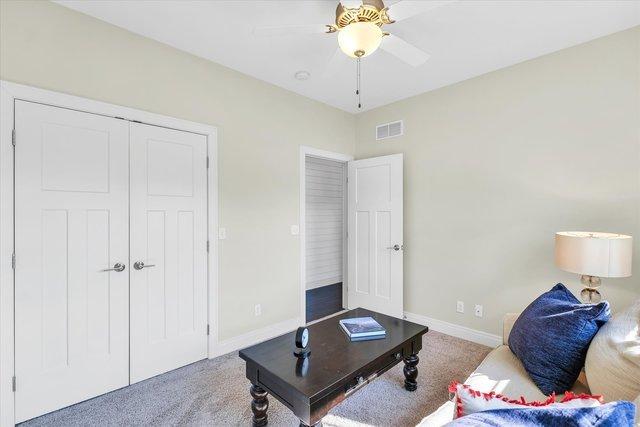 carpeted living room with ceiling fan