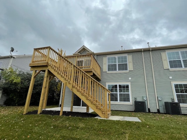 back of property with a lawn and central AC unit