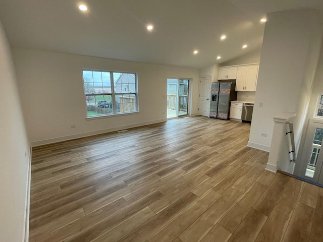 unfurnished living room with light hardwood / wood-style flooring and vaulted ceiling